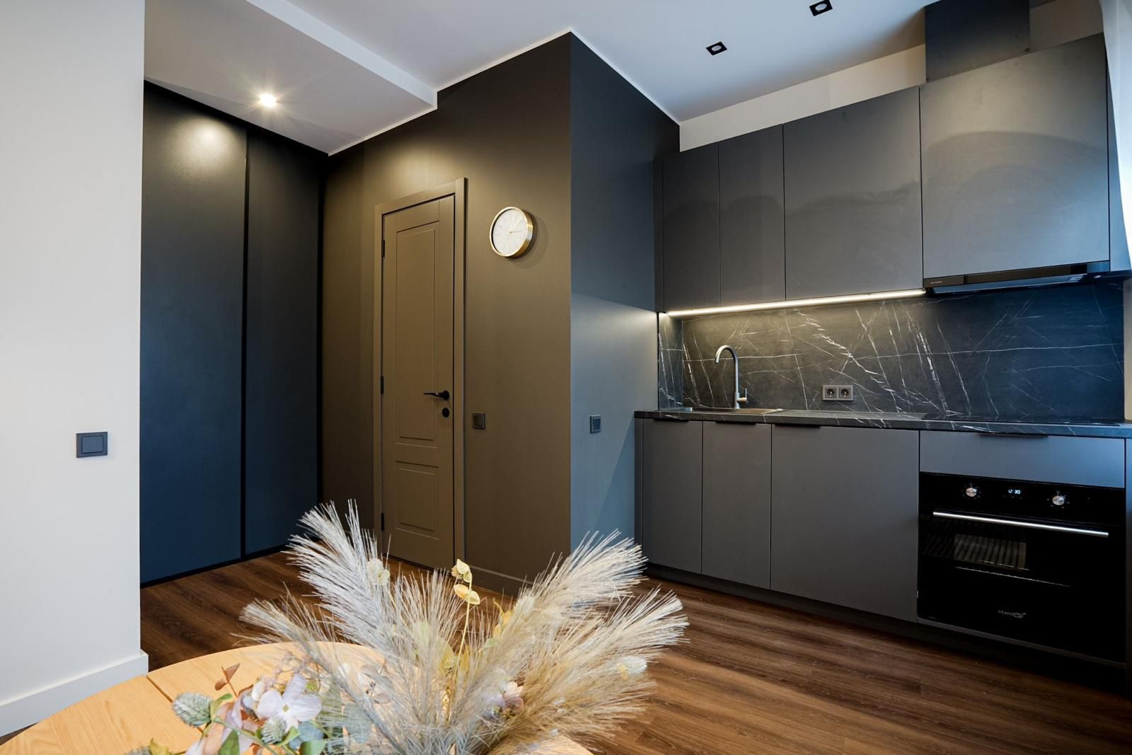 Modern kitchen with dark cabinets and marble backsplash